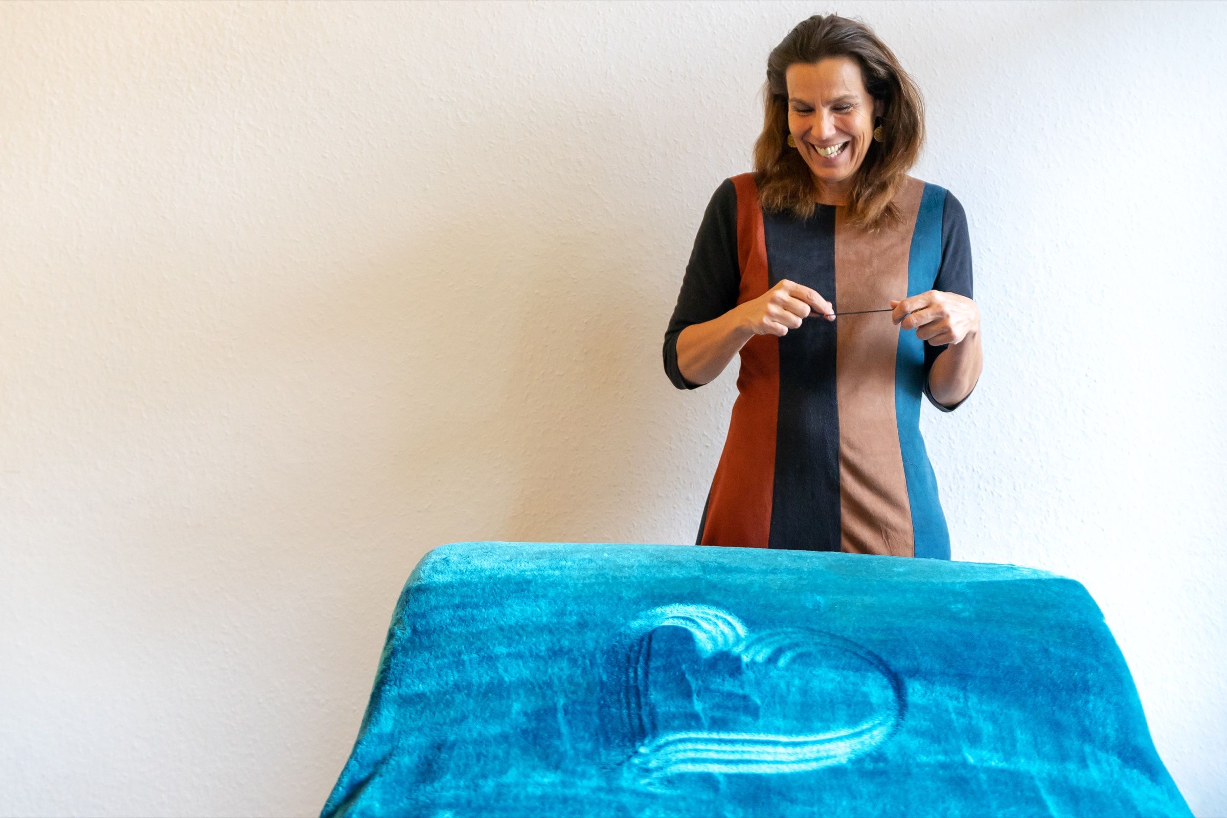 Friederike Gerling lacht hinter einer Liege mit blauer Decke im IHvV